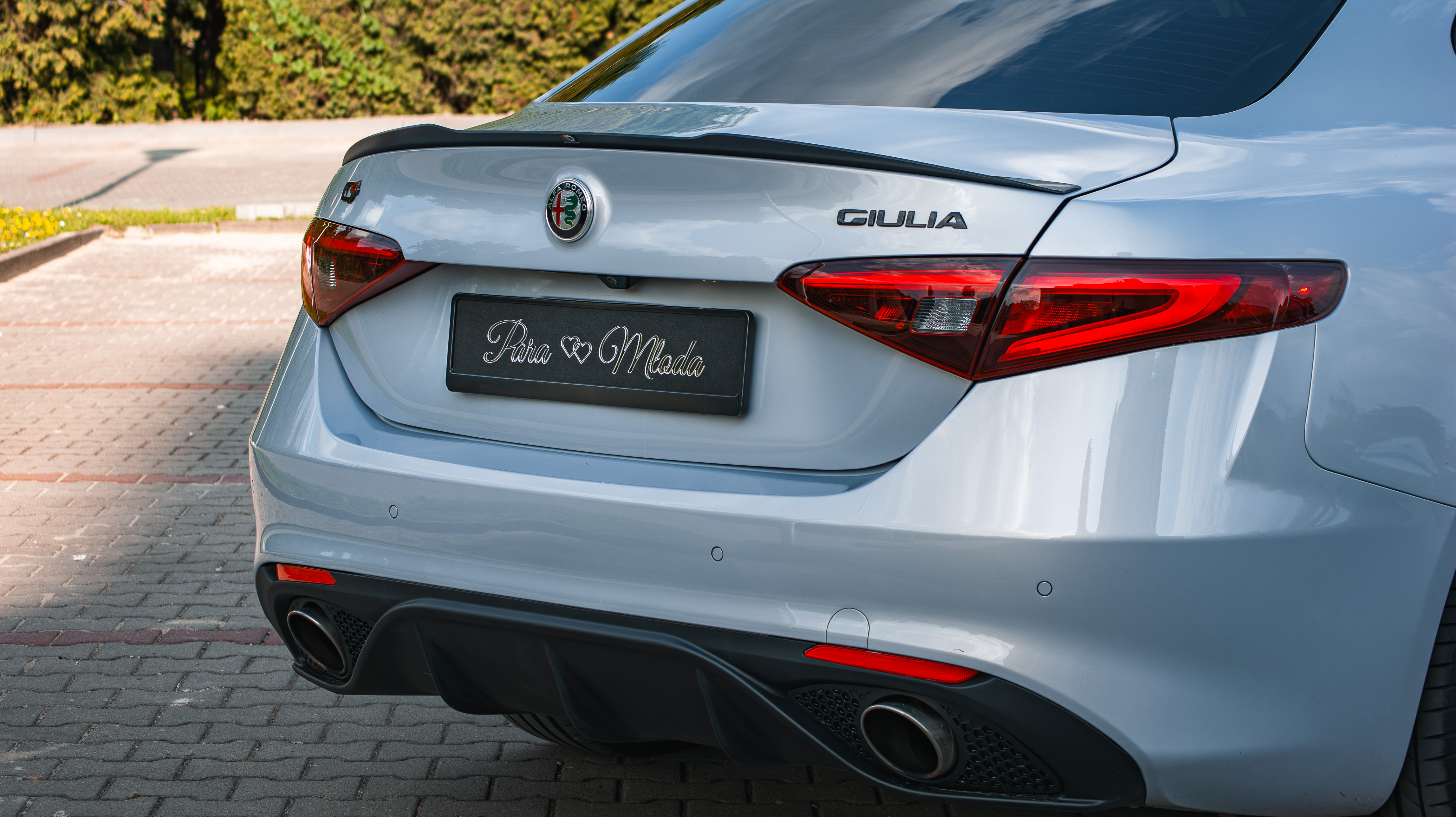 Profesjonalny kierowca w garniturze przy Alfa Romeo Giulia